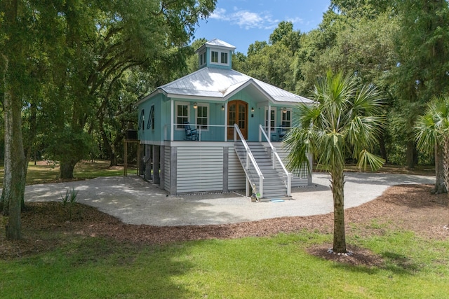 16 Oakwood Ln, Edisto Island, SC 29438 - coastal inspired home with stairway, covered porch, a metal roof, french doors, and a front yard