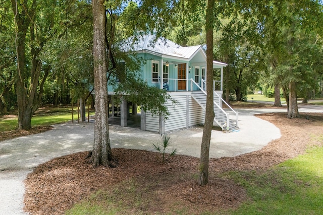16 Oakwood Ln, Edisto Island, SC 29438 - view of front facade with stairway, a porch, a metal roof, and driveway