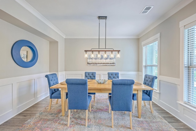 2336 Brinkley Rd, Johns Island, SC 29455 - dining room featuring wood finished floors, wainscoting, a decorative wall, and ornamental molding