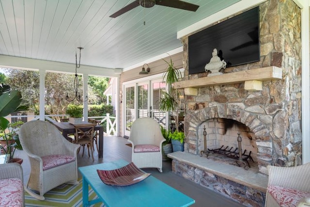 sunroom featuring an outdoor stone fireplace