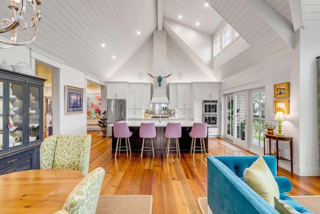 dining room with wood ceiling, light hardwood / wood-style flooring, high vaulted ceiling, beamed ceiling, and a chandelier