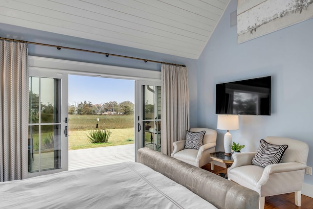 bedroom featuring hardwood / wood-style flooring, lofted ceiling, and access to exterior