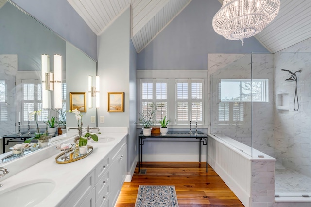 bathroom featuring tiled shower, wood-type flooring, a chandelier, and vanity