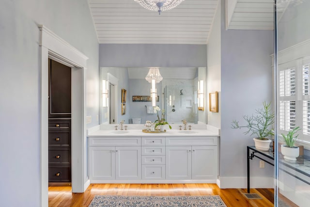 bathroom with walk in shower, wood-type flooring, and vanity