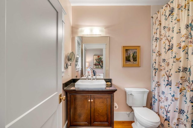 bathroom featuring vanity, hardwood / wood-style flooring, toilet, and walk in shower