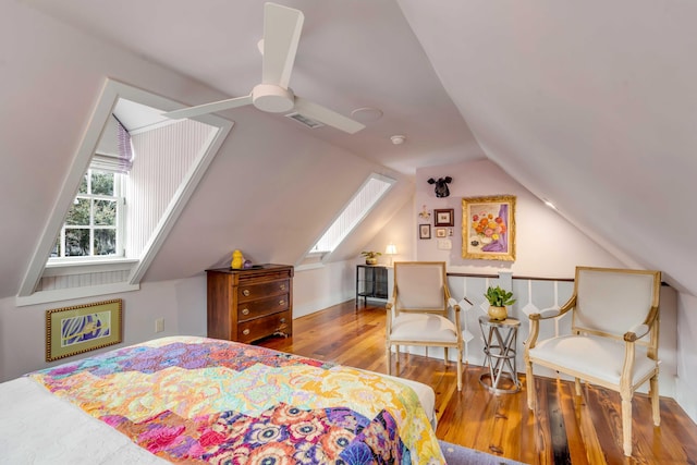 bedroom featuring vaulted ceiling with skylight and hardwood / wood-style floors