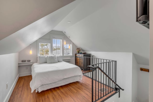 bedroom with wood-type flooring and vaulted ceiling