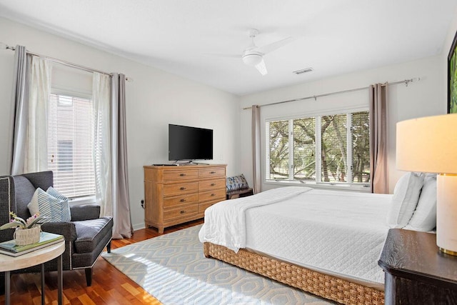 bedroom featuring multiple windows, wood-type flooring, and ceiling fan