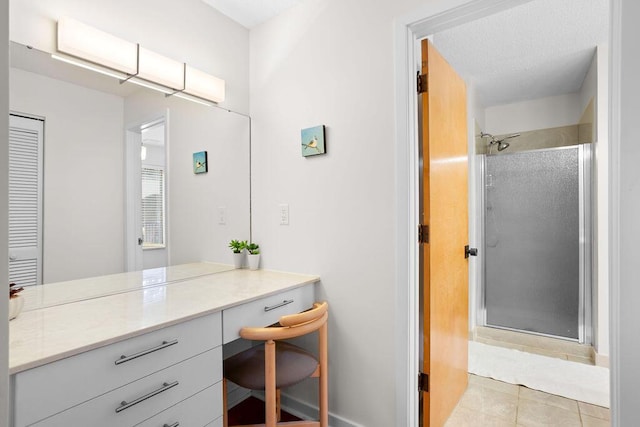 bathroom with tile patterned flooring, vanity, and walk in shower