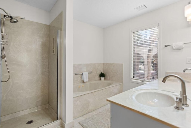 bathroom with vanity and independent shower and bath