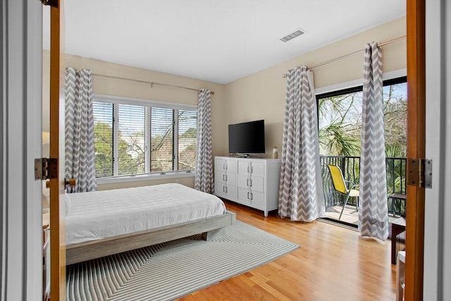 bedroom with access to exterior and light wood-type flooring