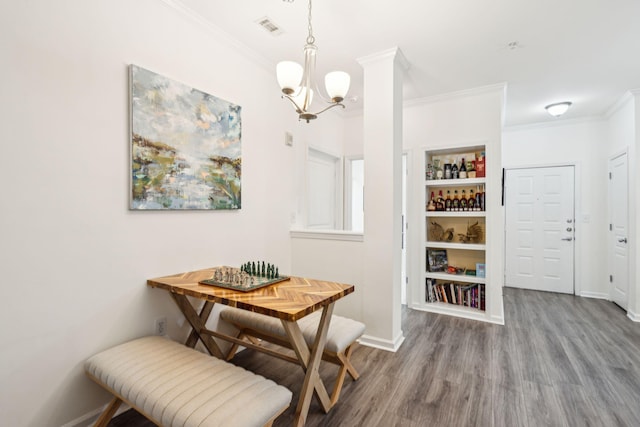 dining space featuring a notable chandelier, ornamental molding, and hardwood / wood-style floors