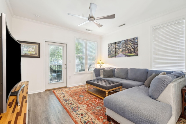 living room featuring crown molding, wood-type flooring, and ceiling fan