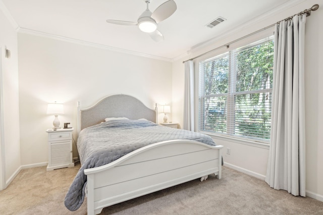 carpeted bedroom featuring ornamental molding and ceiling fan