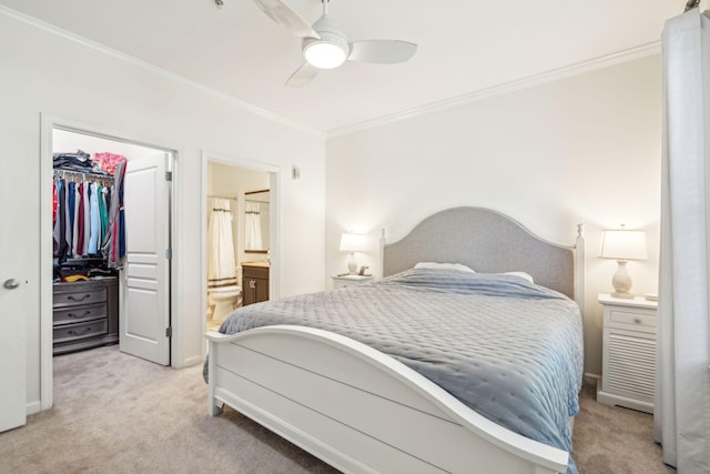 carpeted bedroom featuring connected bathroom, ornamental molding, a closet, and ceiling fan