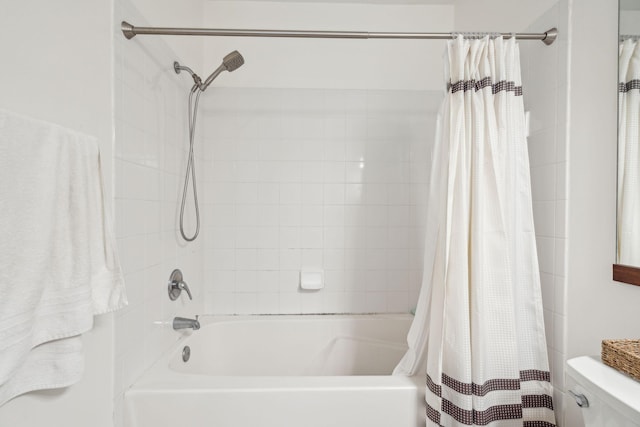 bathroom with shower / tub combo with curtain and toilet