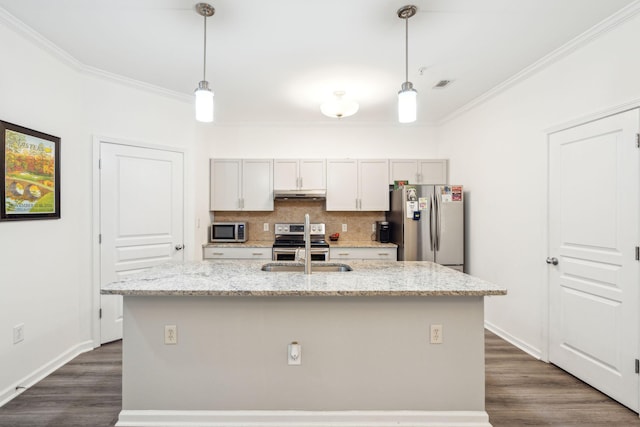 kitchen featuring light stone countertops, appliances with stainless steel finishes, hanging light fixtures, and a kitchen island with sink