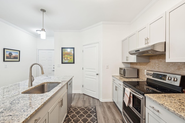 kitchen with white cabinets, light wood-type flooring, stainless steel appliances, sink, and light stone counters