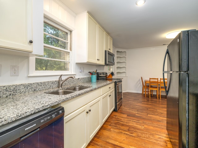 kitchen with hardwood / wood-style flooring, sink, white cabinetry, black appliances, and light stone countertops