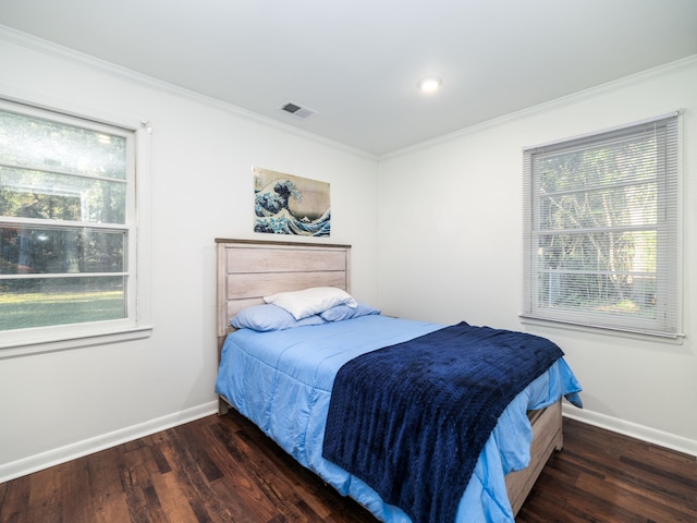 bedroom with ornamental molding and dark hardwood / wood-style flooring