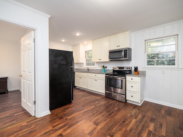 kitchen with light stone countertops, stainless steel appliances, dark hardwood / wood-style floors, and a wealth of natural light