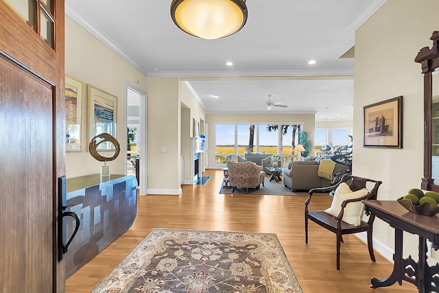 foyer entrance featuring ceiling fan, ornamental molding, and light hardwood / wood-style flooring