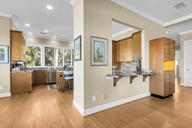 kitchen featuring a kitchen bar, decorative backsplash, stainless steel dishwasher, light hardwood / wood-style floors, and kitchen peninsula