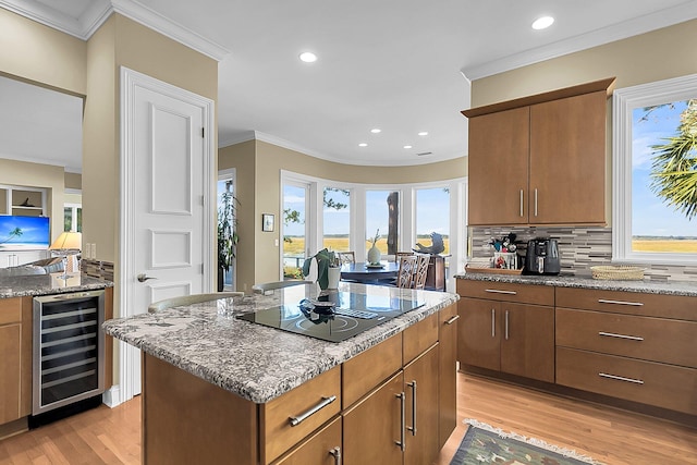 kitchen with crown molding, light hardwood / wood-style flooring, beverage cooler, and stone counters