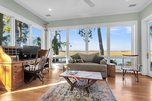 sunroom with a water view, a healthy amount of sunlight, and ceiling fan