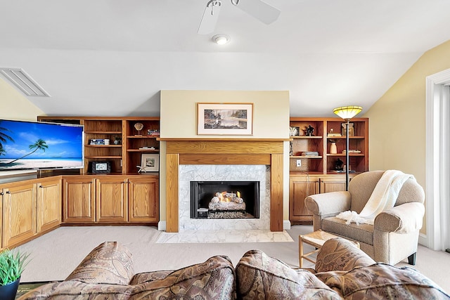 living room with vaulted ceiling, light carpet, ceiling fan, and a fireplace