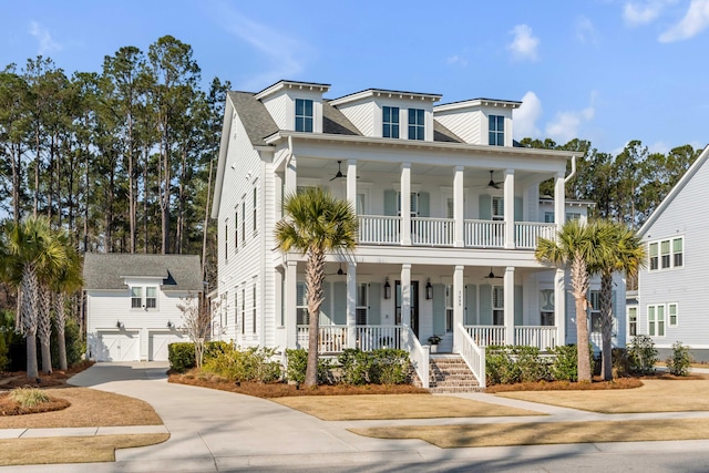 view of front of home featuring an outbuilding, a porch, a balcony, a garage, and a ceiling fan