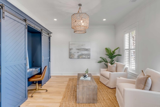 interior space featuring light wood finished floors, a barn door, ornamental molding, and baseboards