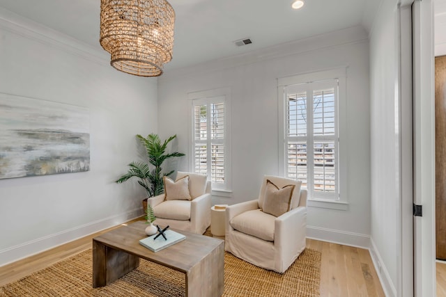 living area featuring plenty of natural light, visible vents, and crown molding