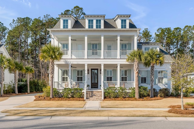 neoclassical / greek revival house with a ceiling fan, covered porch, and a balcony