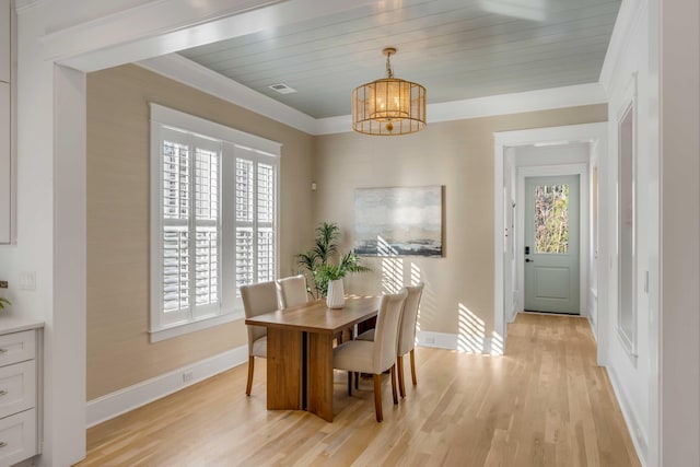 dining area with a chandelier, ornamental molding, baseboards, and light wood-style floors