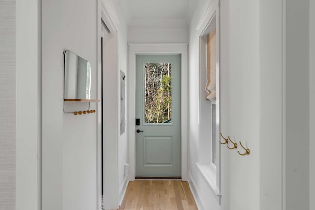 doorway to outside featuring crown molding and light wood-style flooring