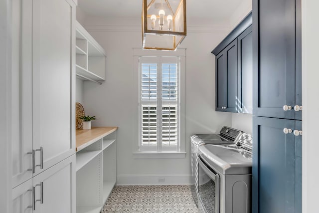 clothes washing area featuring ornamental molding, separate washer and dryer, cabinet space, and baseboards