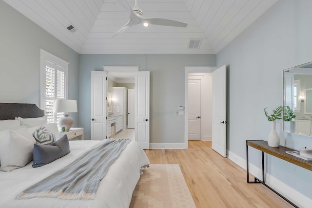 bedroom with baseboards, vaulted ceiling, visible vents, and light wood-style floors