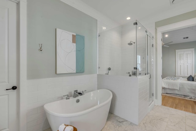 ensuite bathroom featuring a stall shower, marble finish floor, a freestanding bath, and ensuite bath