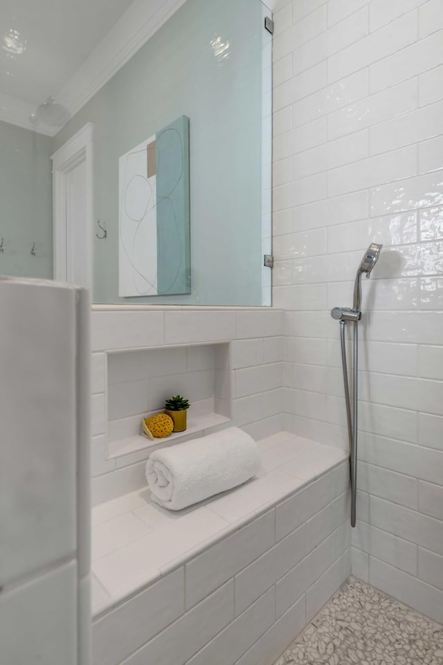 bathroom with crown molding and tiled shower