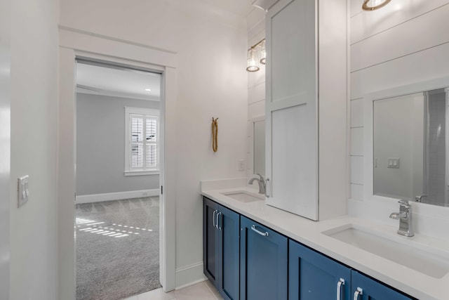 full bath with double vanity, baseboards, and a sink