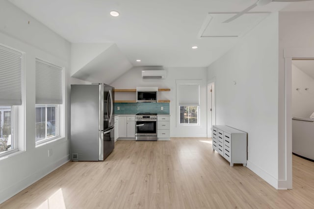 kitchen featuring a wall unit AC, appliances with stainless steel finishes, light wood-type flooring, open shelves, and tasteful backsplash