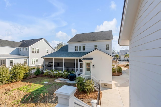 back of house featuring crawl space, a sunroom, and a shingled roof