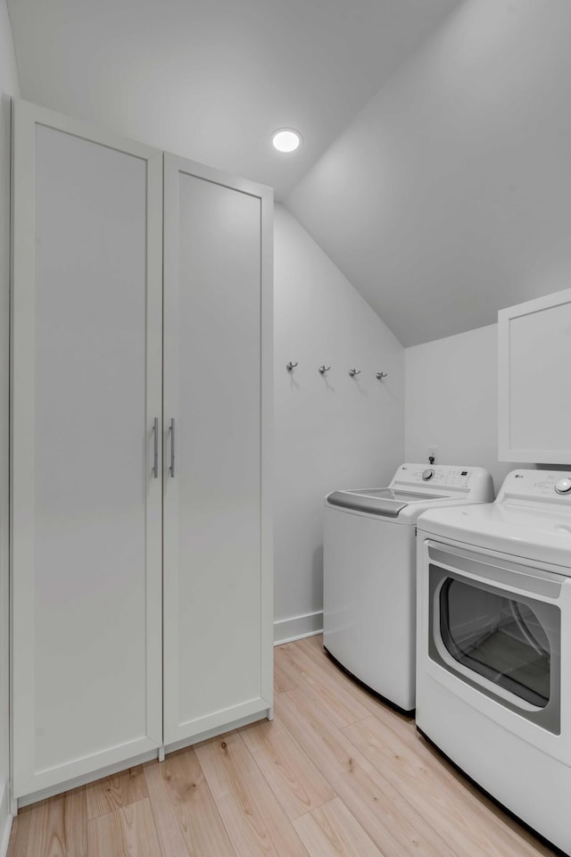 clothes washing area featuring laundry area, light wood finished floors, recessed lighting, and washer and dryer