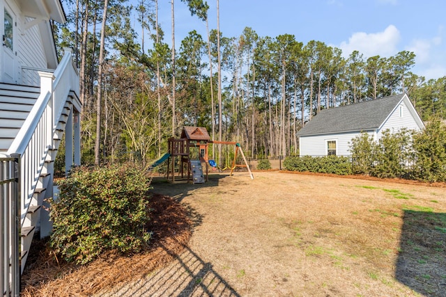 view of yard featuring stairway, a playground, and fence