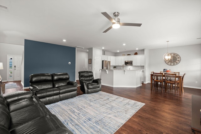 living room with dark hardwood / wood-style floors and ceiling fan