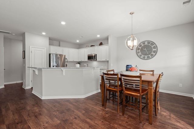 dining space featuring dark wood-type flooring and a notable chandelier