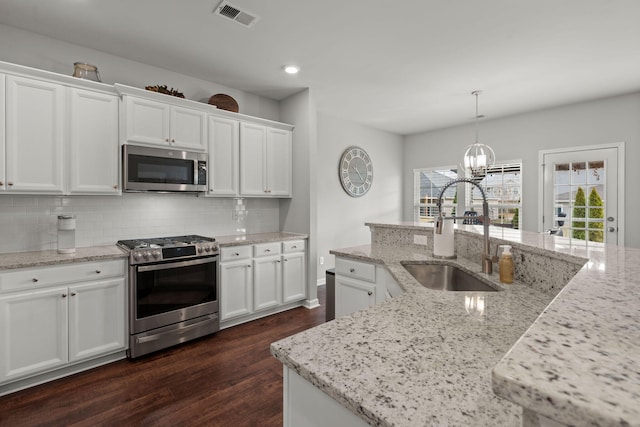 kitchen with light stone countertops, appliances with stainless steel finishes, and white cabinets