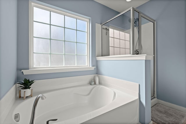 bathroom featuring a wealth of natural light and separate shower and tub