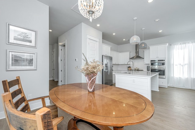 dining space featuring an inviting chandelier and light hardwood / wood-style floors